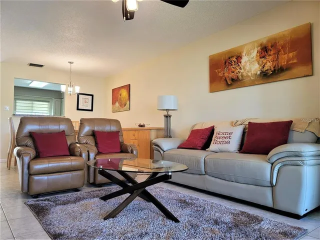 a living room with furniture a rug and a painting on the wall