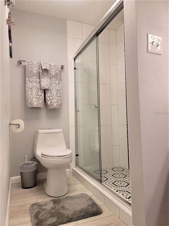 5147 Willow Links, Unit 18 Sarasota, FL 34235 - Photo 26 of 30 a bathroom with a toilet and a shower curtain