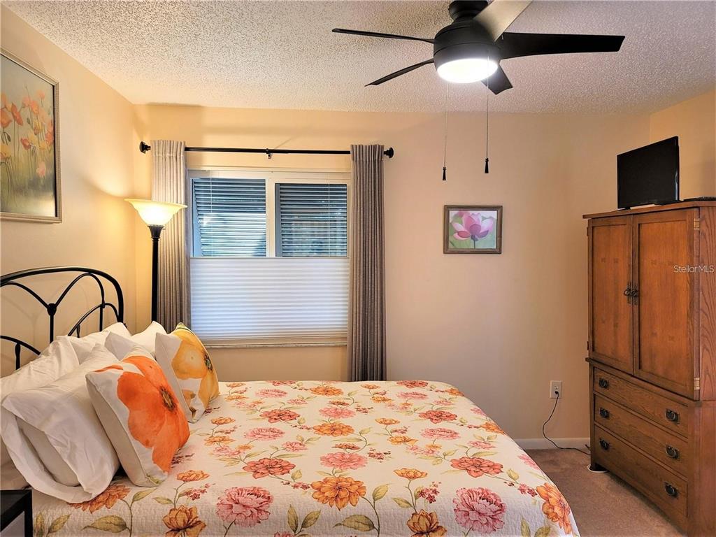 5147 Willow Links, Unit 18 Sarasota, FL 34235 - Photo 27 of 30 a bedroom with a bed and a flat tv screen on the dresser