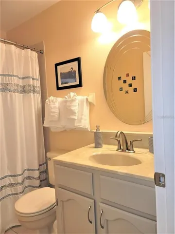 a bathroom with a sink mirror vanity and toilet