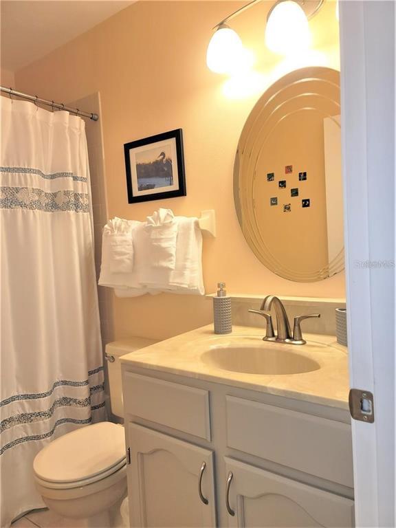 5147 Willow Links, Unit 18 Sarasota, FL 34235 - Photo 28 of 30 a bathroom with a sink mirror vanity and toilet