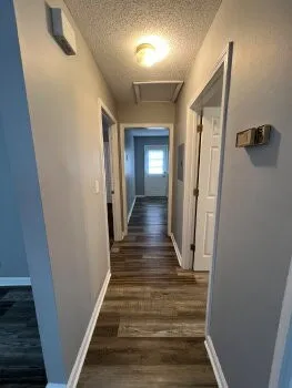 a view of a hallway with wooden floor and staircase