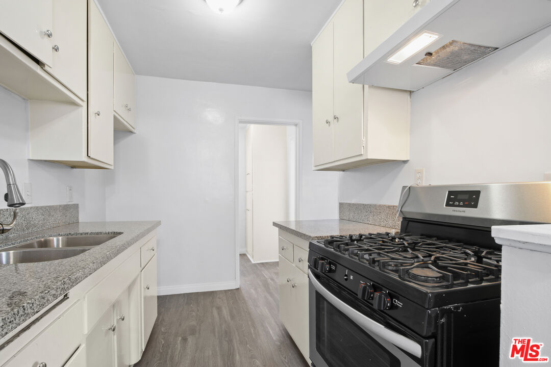 115 North Oak Street, Unit 15 Inglewood, CA 90301 - Photo 10 of 16 a kitchen with granite countertop a sink stove and cabinets