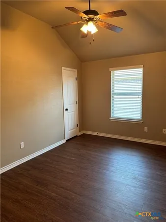 an empty room with wooden floor and chandelier fan