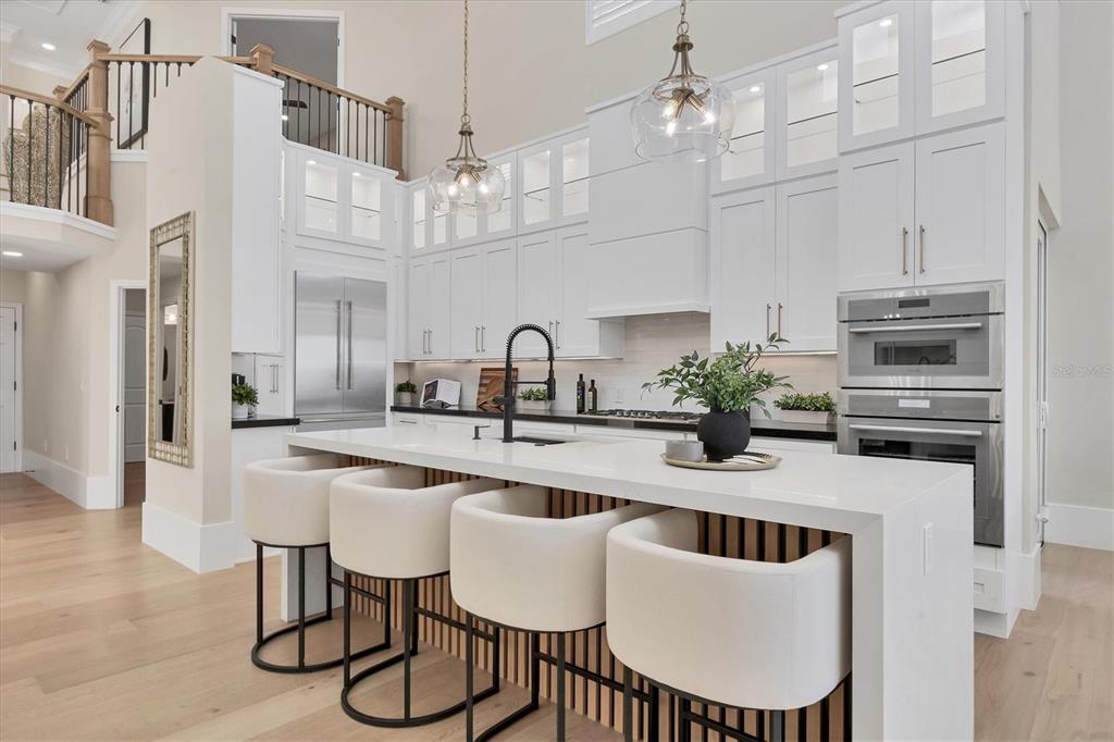3540 Mistletoe Lane Longboat Key, FL 34228 - Photo 23 of 80 a kitchen with stainless steel appliances kitchen island granite countertop a table chairs in it and white cabinets