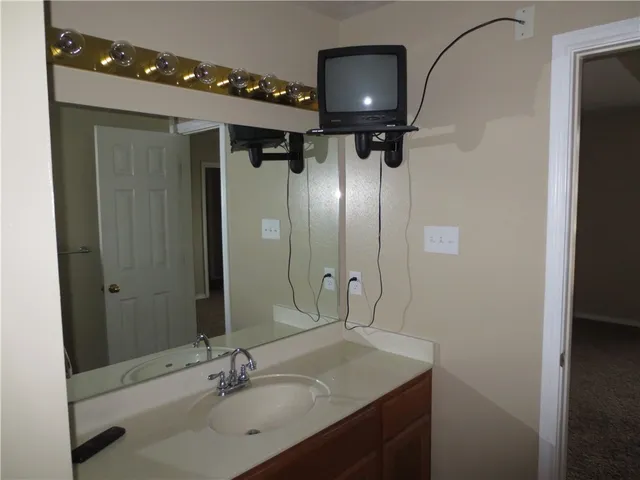 a bathroom with a sink vanity granite and a mirror