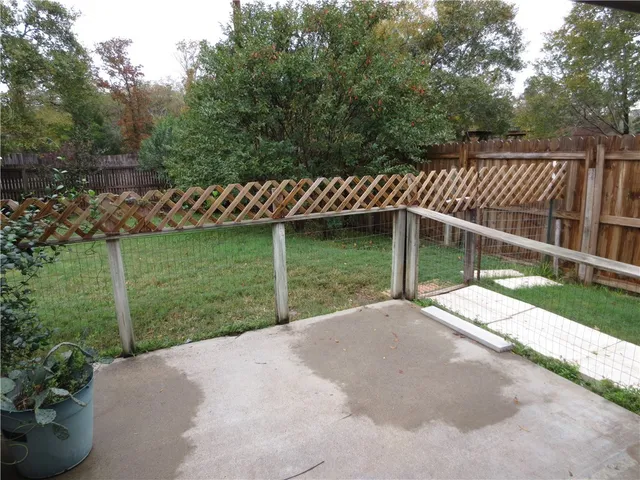 a view of a yard with wooden fence