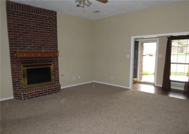 a view of an empty room with a fireplace and a window
