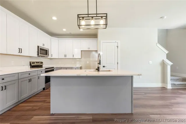 a kitchen with stainless steel appliances a sink stove and refrigerator