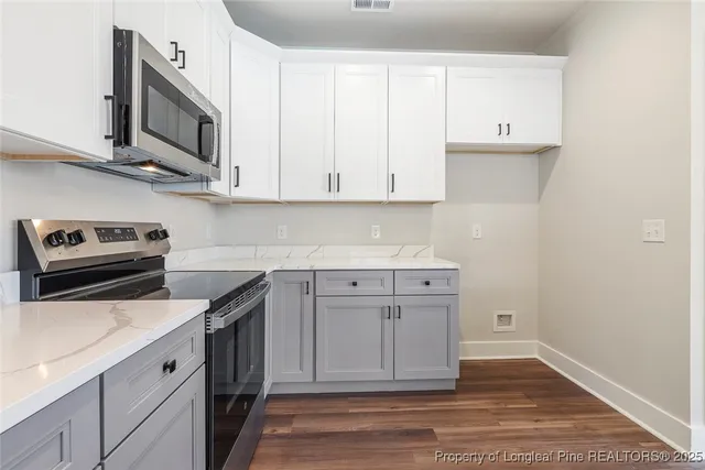 a kitchen with stainless steel appliances granite countertop a sink a stove and a microwave