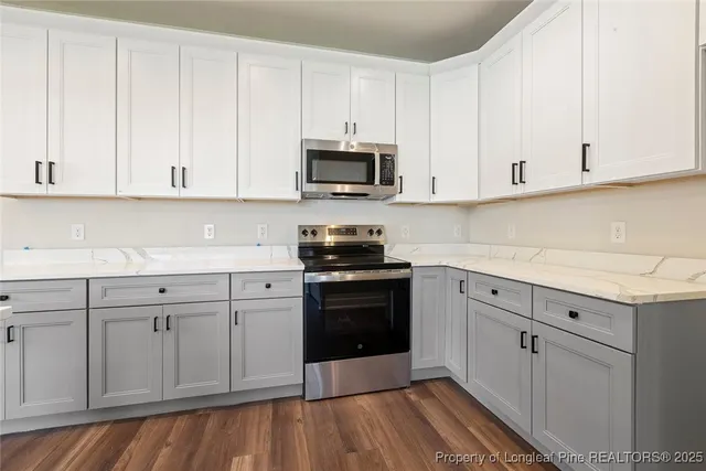 a kitchen with granite countertop white cabinets and white appliances