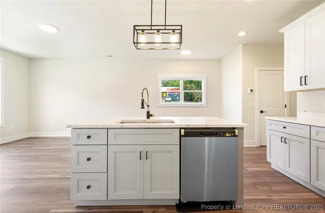a kitchen with stainless steel appliances granite countertop a sink and dishwasher with wooden floor