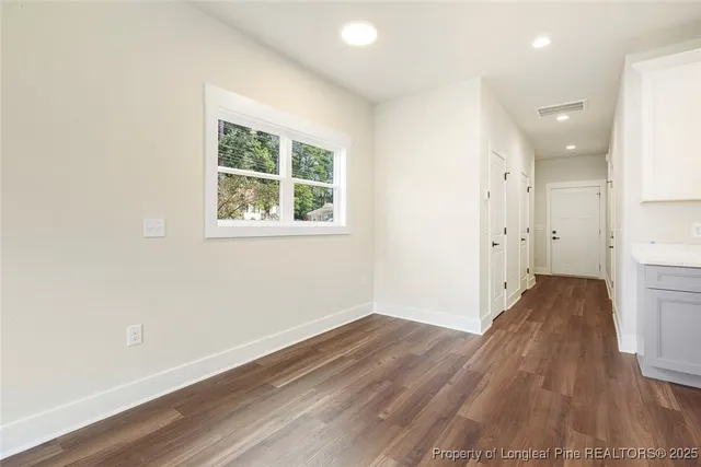 an empty room with wooden floor and a window