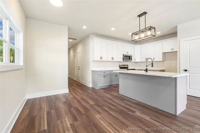a kitchen with kitchen island a sink stainless steel appliances and window