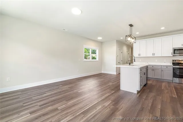 a view of kitchen with granite countertop cabinets and wooden floor