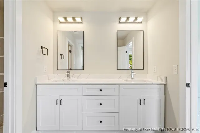 a bathroom with double sink and a mirror