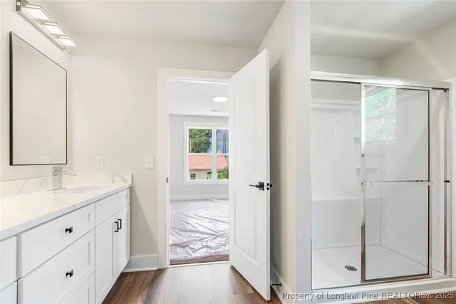 a spacious bathroom with a granite countertop sink mirror and shower