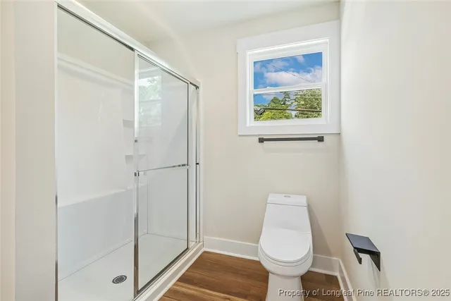 a bathroom with a toilet and a shower