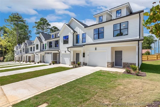 a front view of a house with a yard and trees