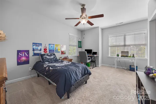 a bedroom with bed and ceiling fan