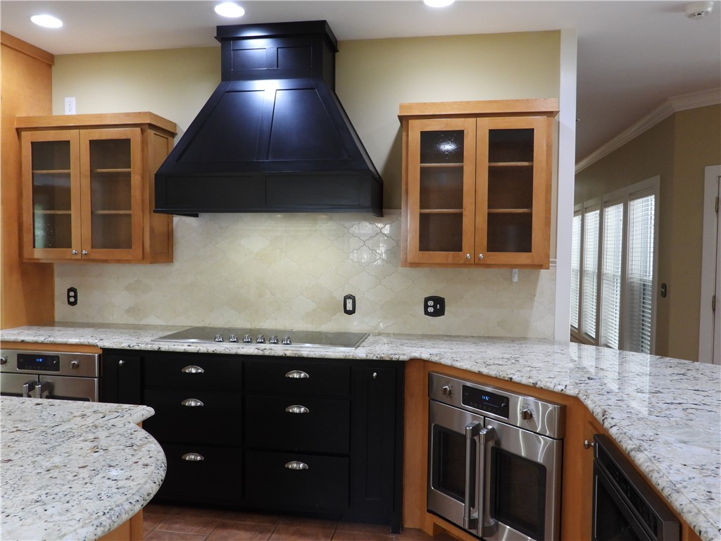 19489 Oak Circle Springdale, AR 72764 - Photo 8 of 58 Modern kitchen featuring a black range hood, stainless steel double ovens, and a black cooktop