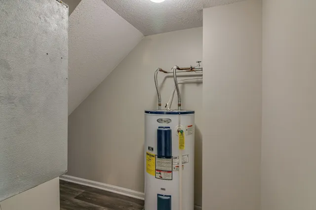 an empty room with chandelier fan and windows