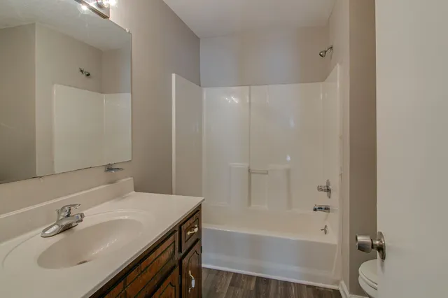 an empty room with a chandelier fan and windows