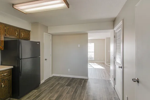a view of a refrigerator in kitchen and wooden floor