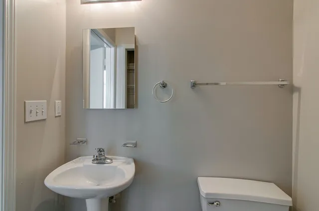 a bathroom with a sink a toilet and mirror
