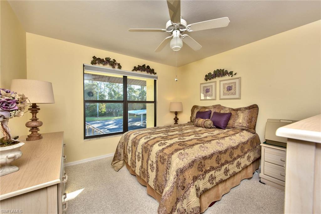 4410 Chantelle Drive, Unit H206 Naples, FL 34112 - Photo 14 of 25 a bedroom with a large bed and a chandelier