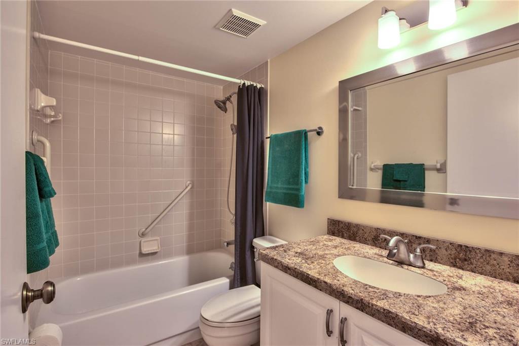 4410 Chantelle Drive, Unit H206 Naples, FL 34112 - Photo 15 of 25 a bathroom with a granite countertop bathtub shower sink vanity and toilet