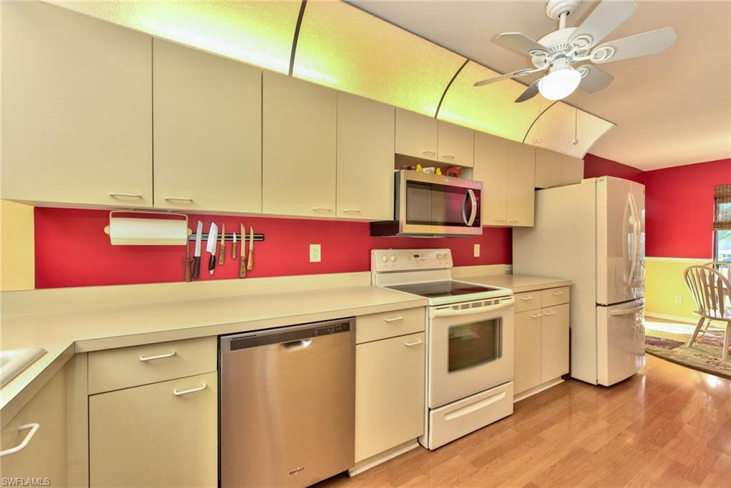 4410 Chantelle Drive, Unit H206 Naples, FL 34112 - Photo 18 of 25 a kitchen with stainless steel appliances a stove refrigerator and microwave