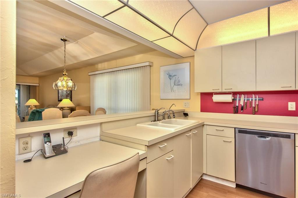 4410 Chantelle Drive, Unit H206 Naples, FL 34112 - Photo 19 of 25 a kitchen with a sink a counter space and cabinets