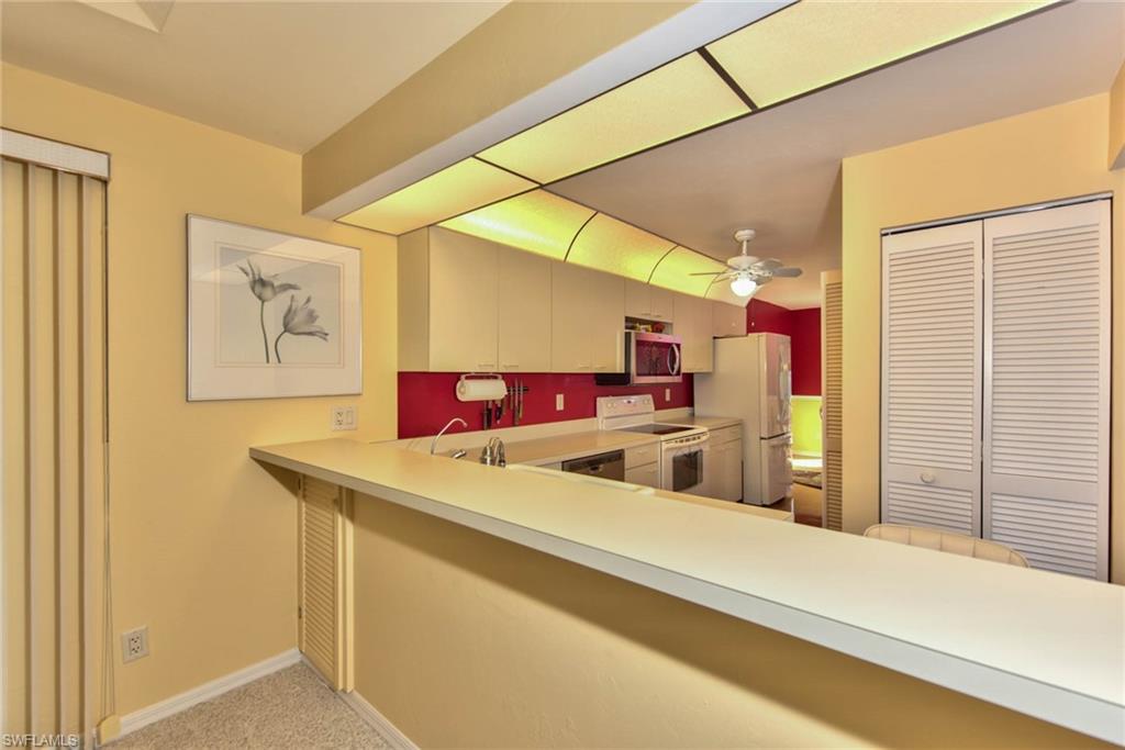 4410 Chantelle Drive, Unit H206 Naples, FL 34112 - Photo 20 of 25 a view of a kitchen with a sink and a refrigerator