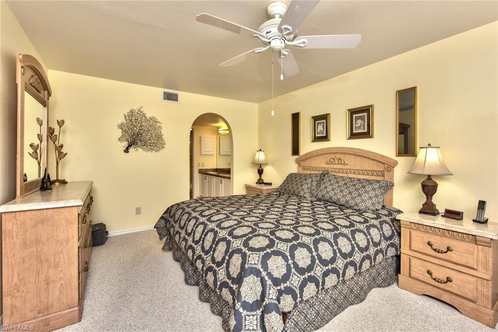 4410 Chantelle Drive, Unit H206 Naples, FL 34112 - Photo 7 of 25 a bedroom with a large bed and a chandelier