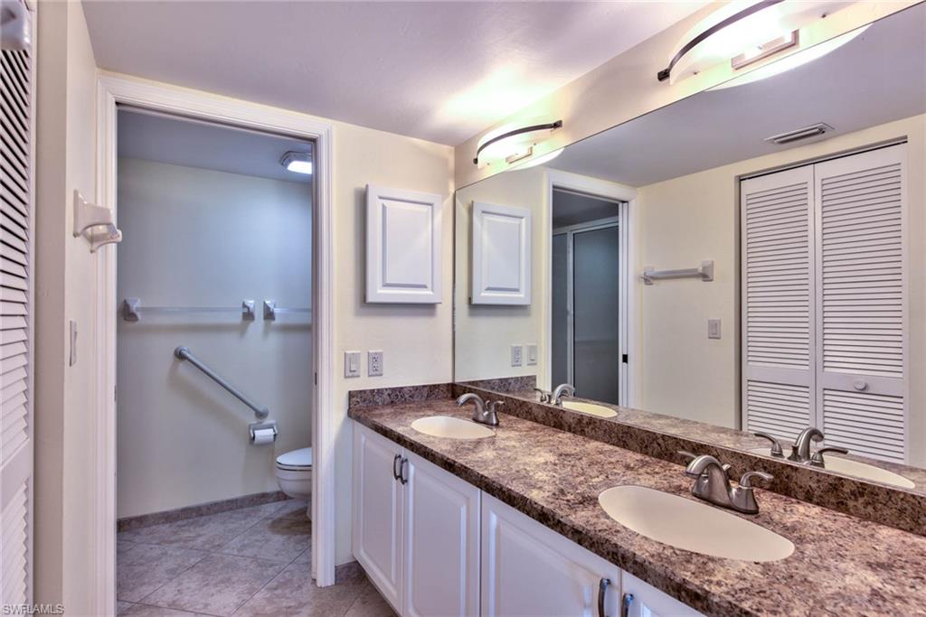 4410 Chantelle Drive, Unit H206 Naples, FL 34112 - Photo 8 of 25 a bathroom with a granite countertop sink and a mirror
