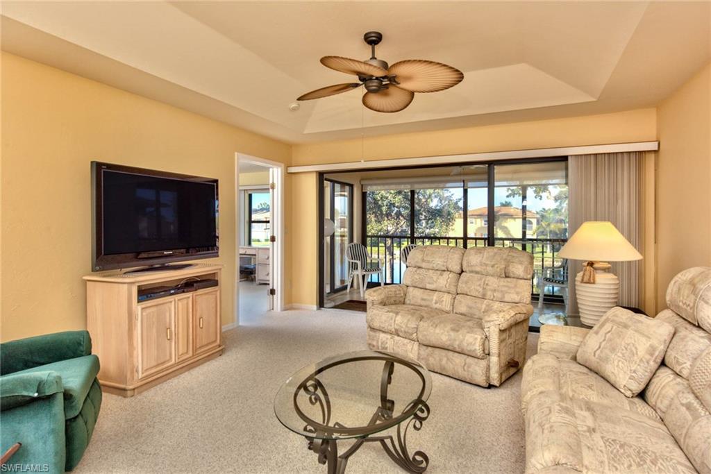 4410 Chantelle Drive, Unit H206 Naples, FL 34112 - Photo 10 of 25 a living room with furniture a flat screen tv and a large window
