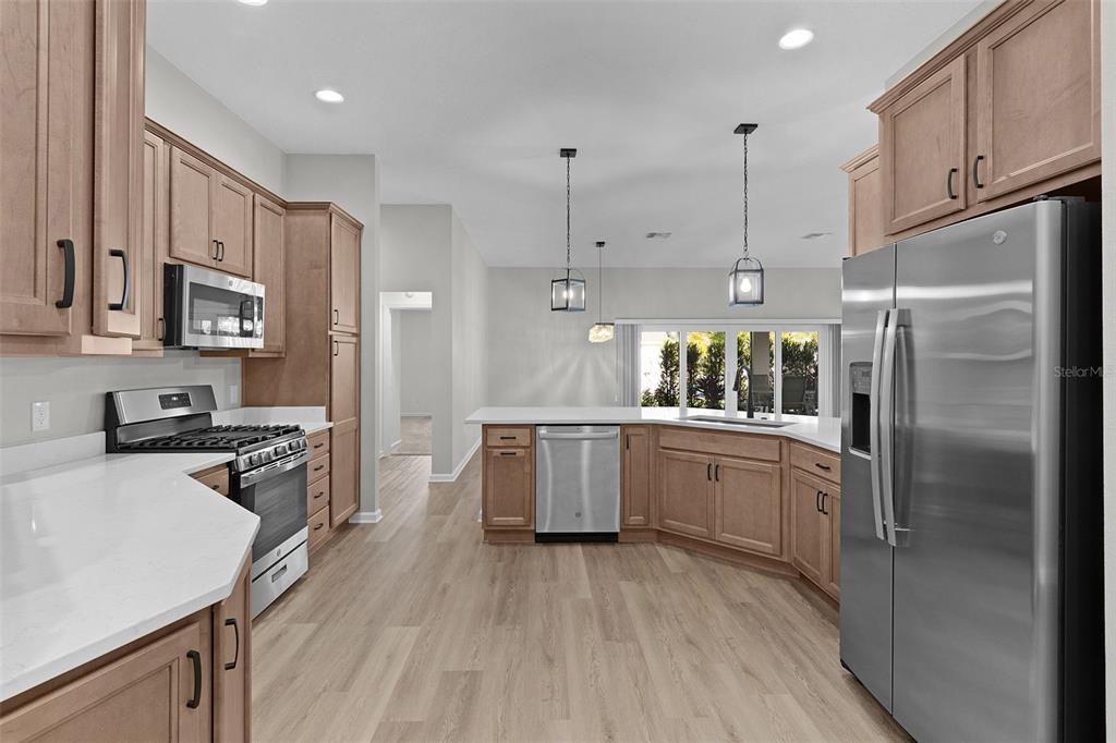 1177 Elkington Road The Villages, FL 34762 - Photo 11 of 59 a kitchen with kitchen island wooden floors appliances and cabinets