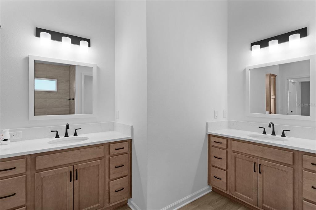 1177 Elkington Road The Villages, FL 34762 - Photo 24 of 59 a bathroom with a double vanity sink and mirror