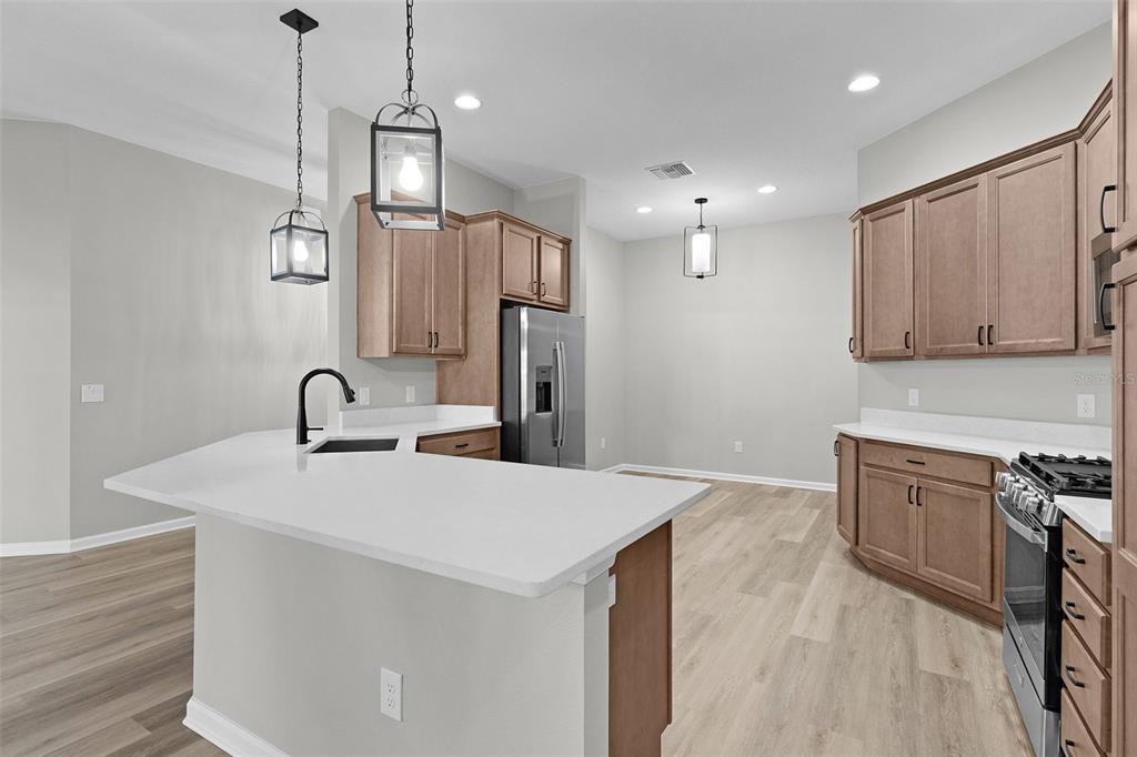 1177 Elkington Road The Villages, FL 34762 - Photo 9 of 59 a kitchen with stainless steel appliances a sink stove and refrigerator
