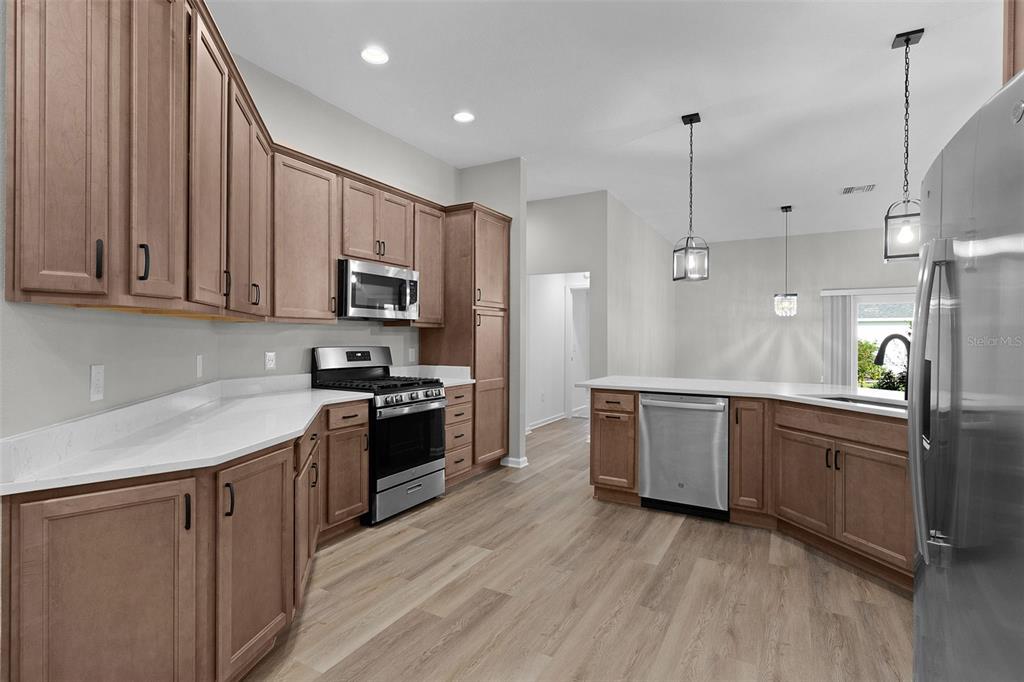 1177 Elkington Road The Villages, FL 34762 - Photo 10 of 59 a kitchen with stainless steel appliances granite countertop a stove a sink and a refrigerator