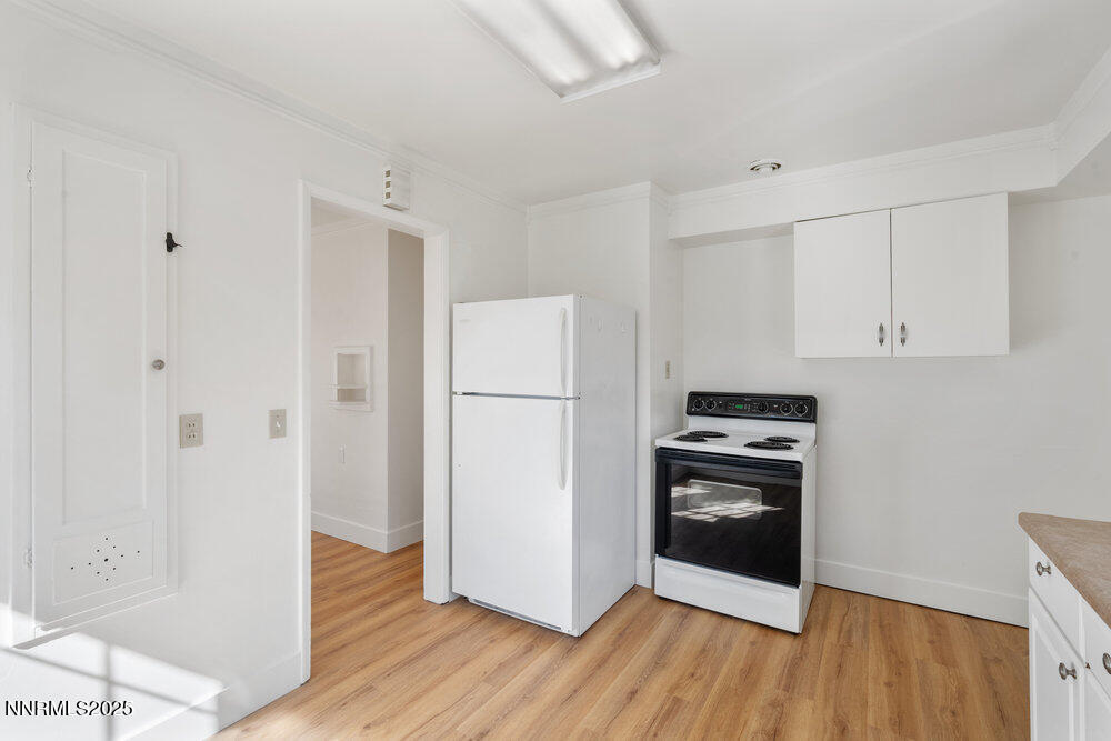80 Locust Street Reno, NV 89502 - Photo 33 of 49 a kitchen with a refrigerator a stove top oven and wooden floor