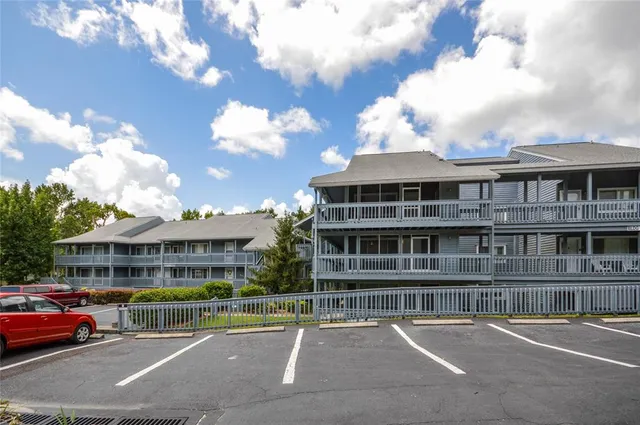 a front view of building with lot of cars and trees