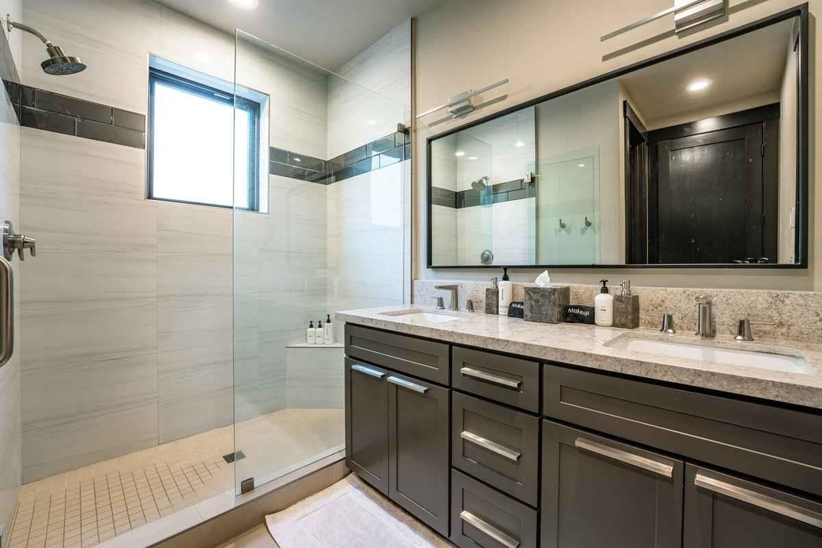 1055 Martis Landing, Unit B Truckee, CA 96161 - Photo 16 of 24 a bathroom with a double vanity sink a mirror and a shower