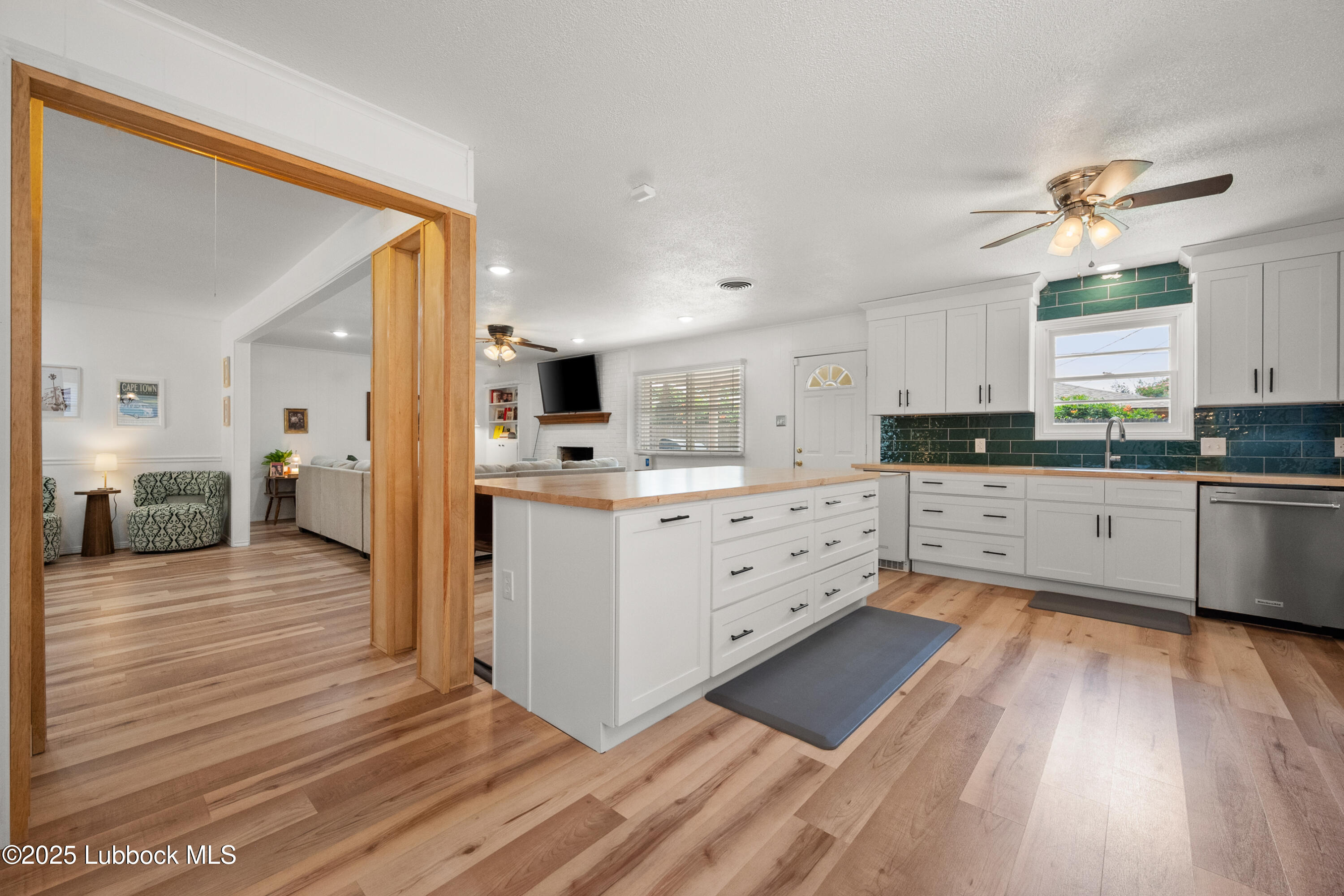 6405 Joliet Avenue Lubbock, TX 79413 - Photo 16 of 30 a large kitchen with cabinets wooden floor and stainless steel appliances