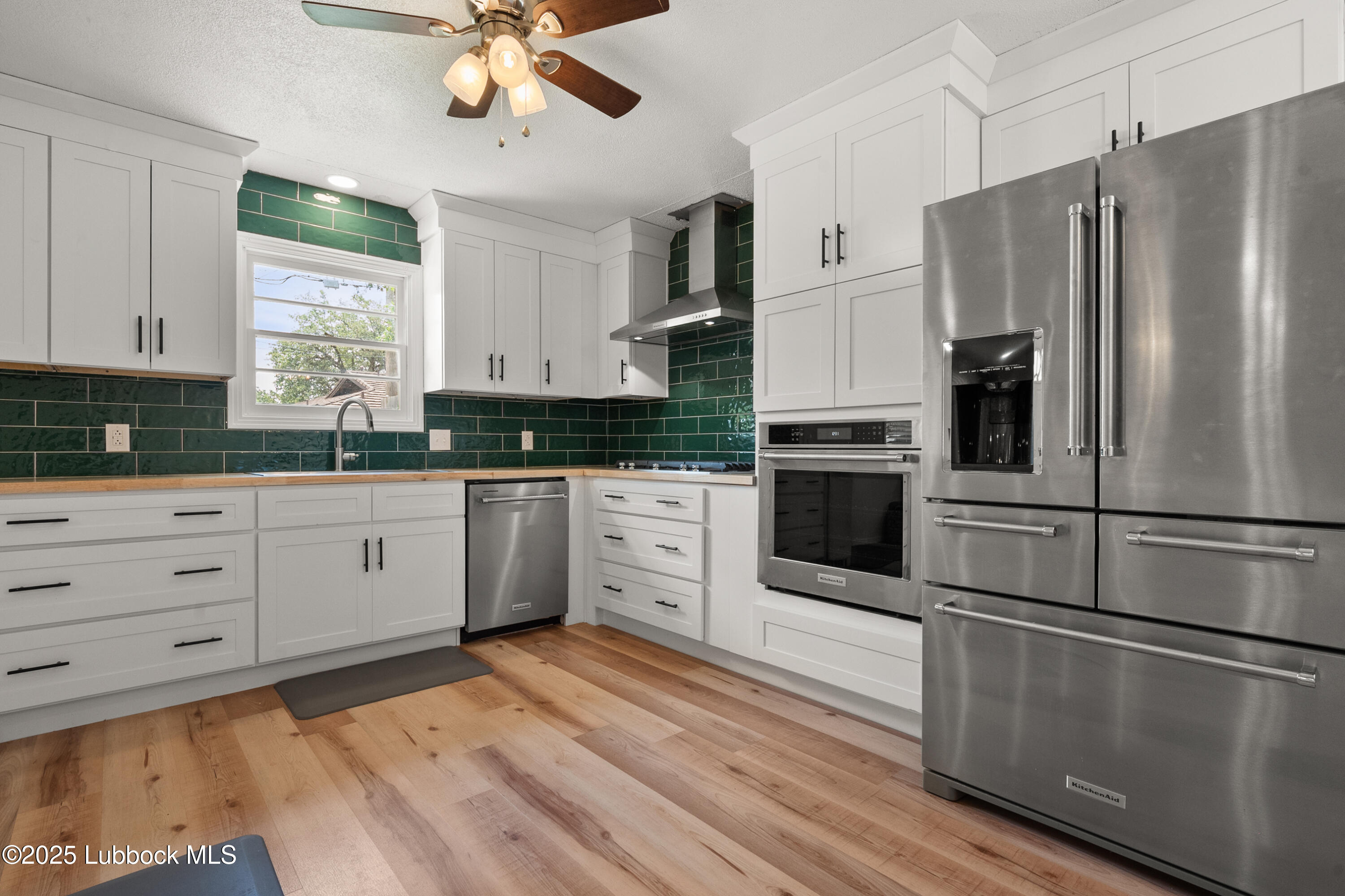 6405 Joliet Avenue Lubbock, TX 79413 - Photo 18 of 30 a kitchen with white cabinets stainless steel appliances and window