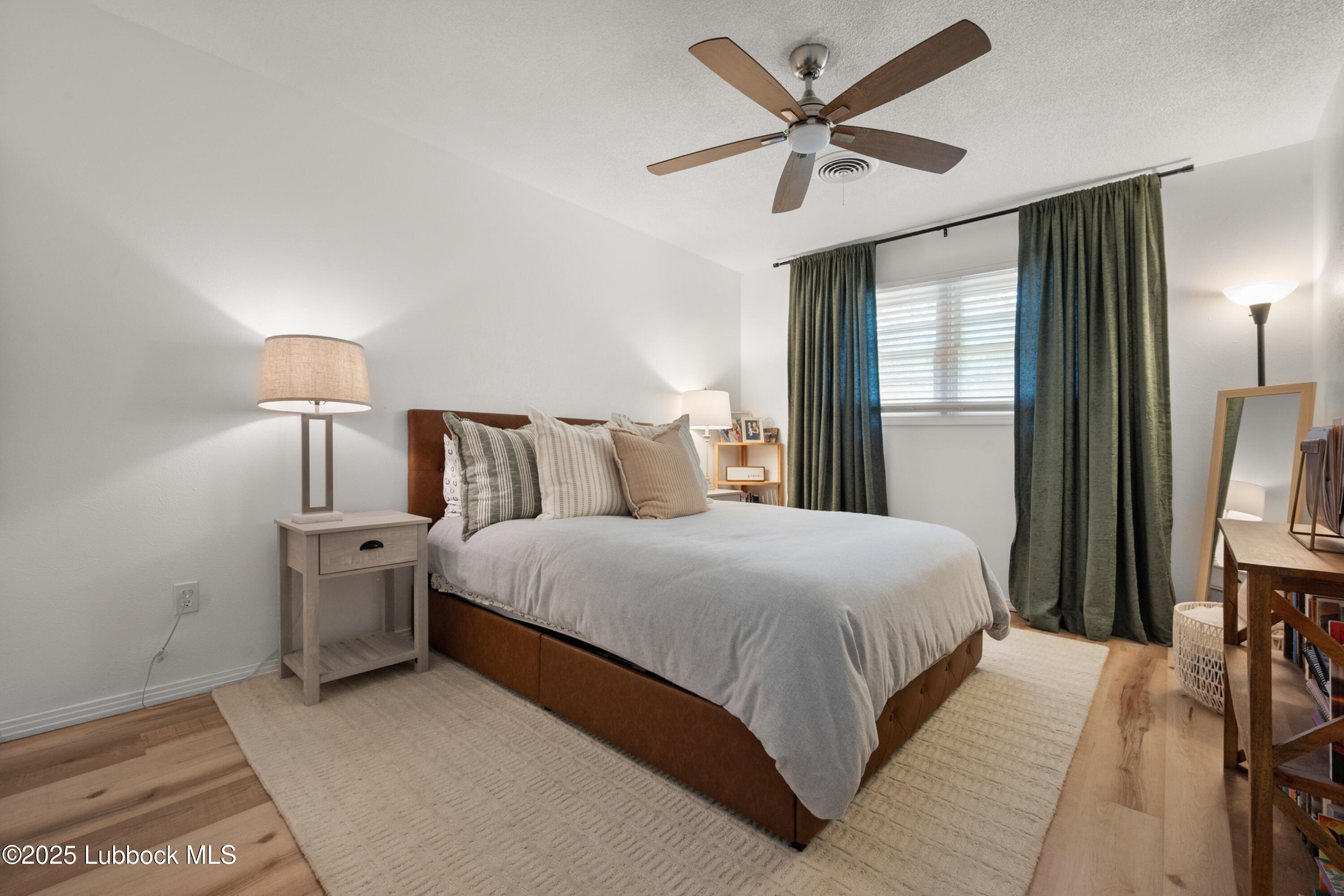 6405 Joliet Avenue Lubbock, TX 79413 - Photo 25 of 30 a bedroom with a bed and a chandelier