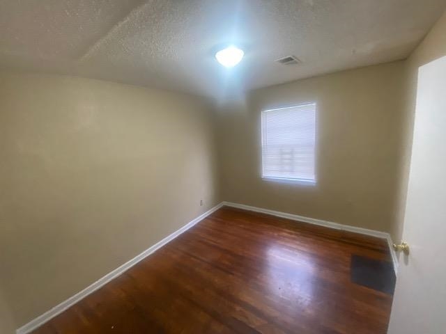 4370 Range Line Road Memphis, TN 38127 - Photo 6 of 14 Unfurnished room featuring dark wood-type flooring and a textured ceiling