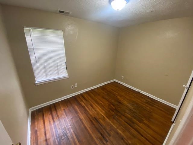 4370 Range Line Road Memphis, TN 38127 - Photo 10 of 14 Unfurnished room featuring dark wood-type flooring and a textured ceiling