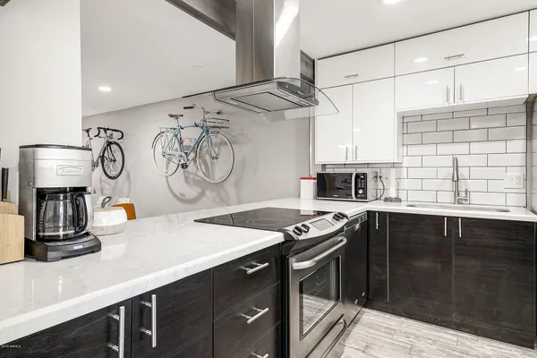 a kitchen with stainless steel appliances a sink stove and cabinets